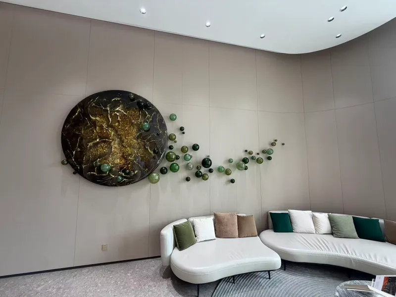 Lobby lounge with large-format greige panels and wall sculpture