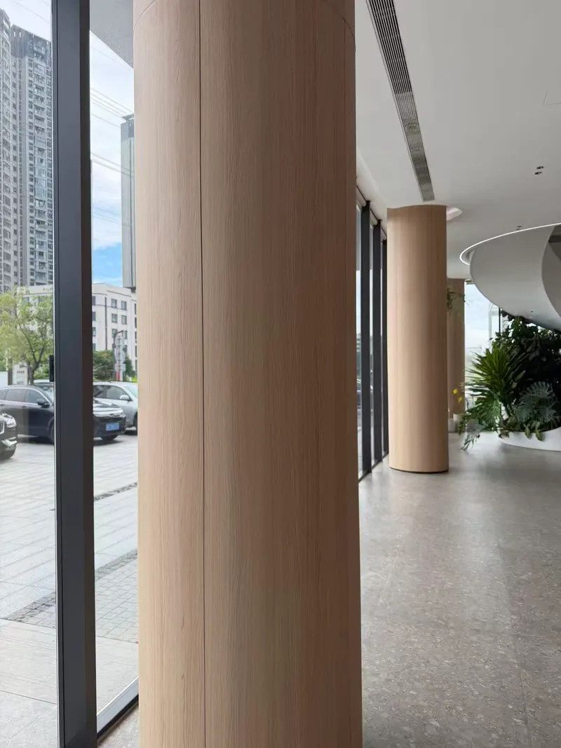 Wood-grain panel cladding on columns in a commercial lobby